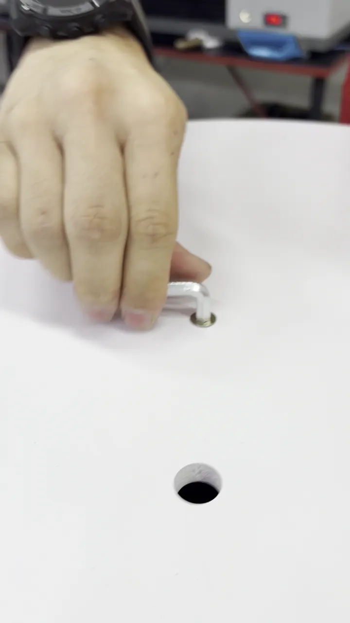 Close-up of the insert nut being fitted into the back of the lucky spin board with an Allen key